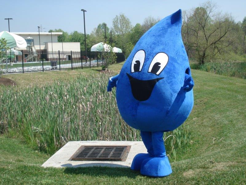 Stormy the mascot next to bioretention